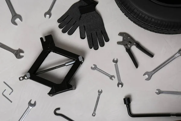 汽车车轮 剃须刀 手套和灰色表面的各种工具 — 图库照片