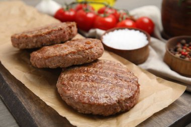 Ahşap masada lezzetli ızgara hamburger köfteleriyle servis masası, yakın plan.