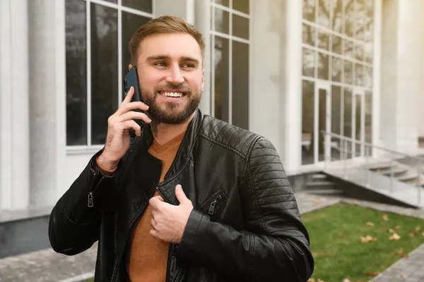 Handsome Man Stylish Leather Jacket Talking Mobile Phone Outdoors — Stock Photo, Image