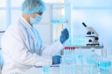 Laboratuvarda numuneyle çalışan bir bilim adamı. Tıbbi araştırma