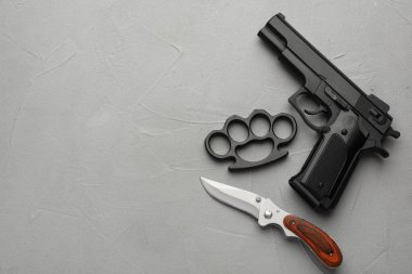 Siyah pirinç muşta, silah ve bıçak açık gri taştan arka planda, düz yerde. Metin için boşluk