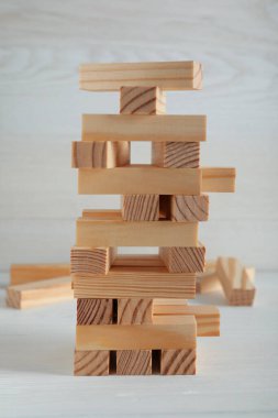 Beyaz masadaki tahta bloklardan yapılmış Jenga kulesi