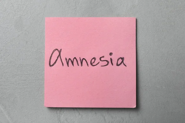 Amnesiaという単語をライトグレーのテーブルの上から見る — ストック写真