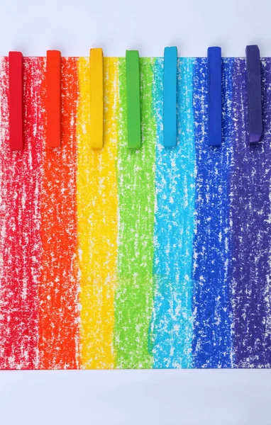 Gökkuşağı resminde renkli pastel tebeşirler, düz uzanmış. Çizim malzemeleri