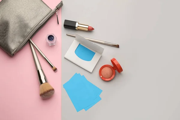 Flat lay composition with facial oil blotting tissues and makeup products on color background, space for text. Mattifying wipes