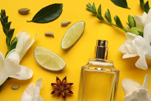 黄色の背景に香水や新鮮な柑橘類のボトルとフラットレイアウト組成物 — ストック写真