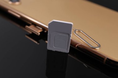 SIM kart, akıllı telefon ve fırlatıcı siyah arkaplanda, yakın plan