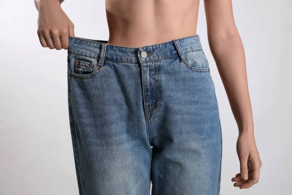 Mulher Magra Jeans Grandes Fundo Claro Close Conceito Perda Peso — Fotografia de Stock