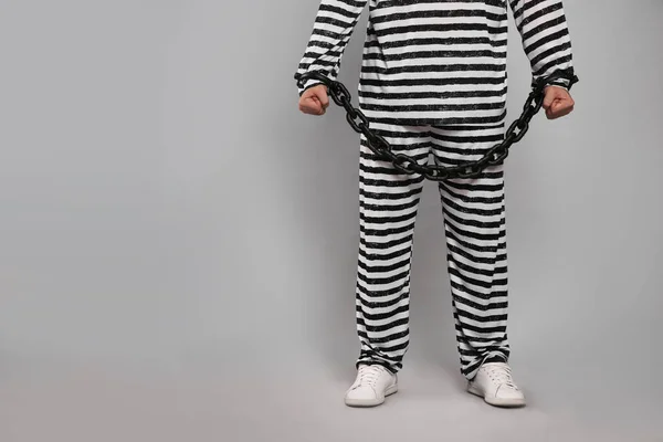 灰色の背景に鎖手で特別な制服を着た囚人 クローズアップ テキストのスペース — ストック写真