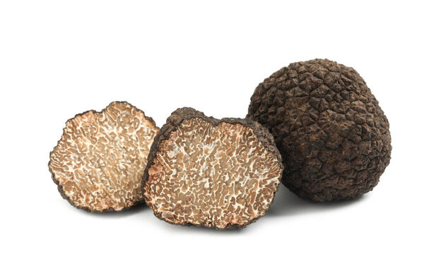 Cut and whole black truffles isolated on white