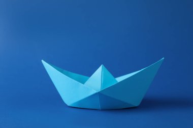 Mavi arka planda el yapımı kağıt tekne. Origami sanatı