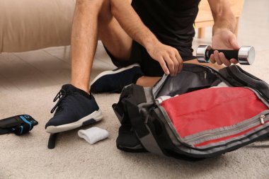 Spor malzemelerini paketleyen adam içeride çantaya dolduruyor, yakın plan.
