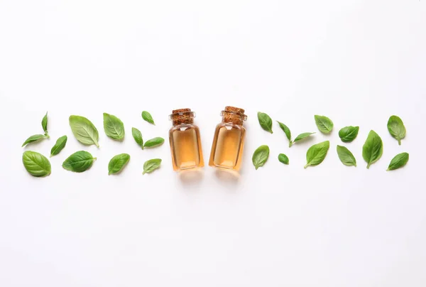 Bottles Essential Basil Oil Fresh Leaves White Background Flat Lay — Stock Photo, Image