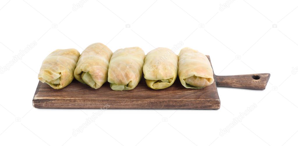 Wooden board with uncooked stuffed cabbage rolls on white background