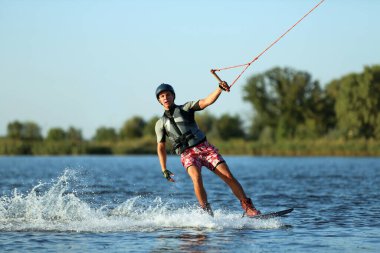Genç çocuk nehirde wakeboard yapıyor. Aşırı su sporu