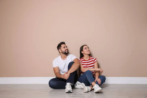 Pareja Joven Sentada Suelo Cerca Pared Beige Interiores — Foto de Stock