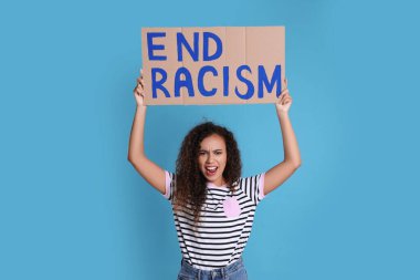 Duygusal Afrikalı Amerikalı kadın açık mavi arka planda ırkçılığı sona erdirme tabelasını tutuyor