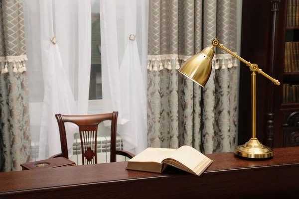 図書室の読書室にある木製のテーブルの上の本とランプ — ストック写真