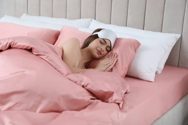 年轻女人睡在柔软的床上 床上铺着丝质的被子 — 图库照片