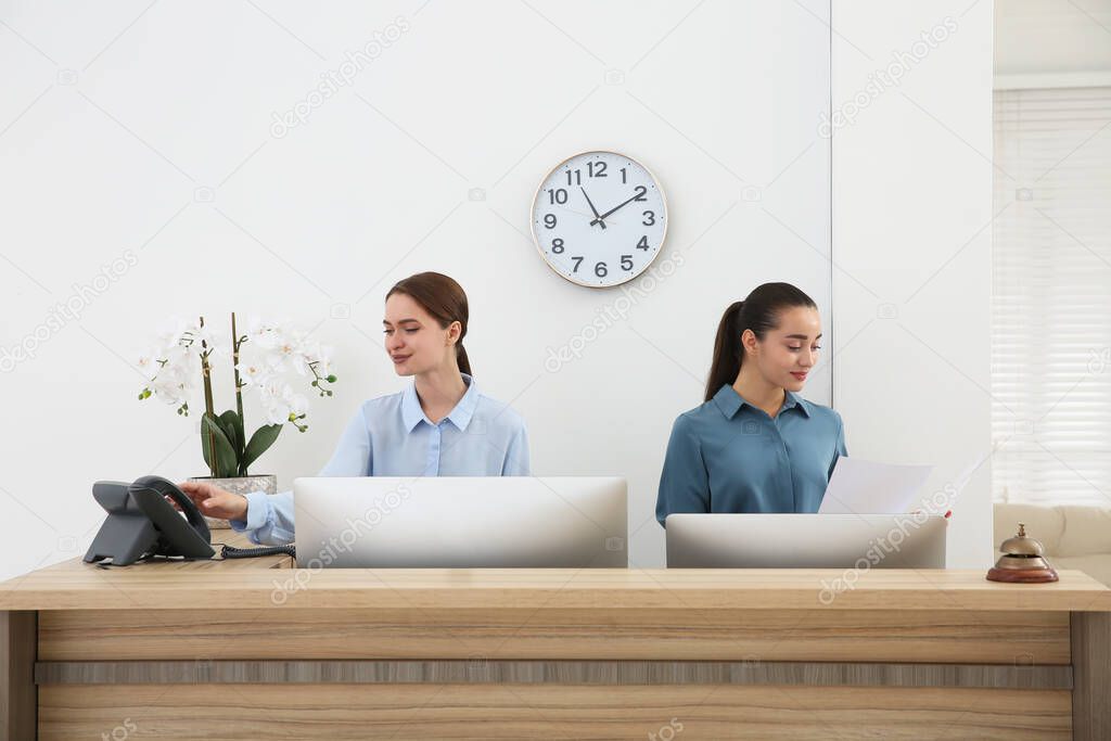 Beautiful receptionists working at counter in hotel