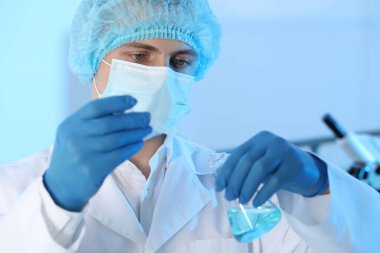 Bilimadamı laboratuarda numuneyi şişeye damlatıyor. Tıbbi araştırma
