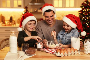 Mutlu baba ve çocukları evde lezzetli Noel kurabiyeleri için para kazanıyorlar.
