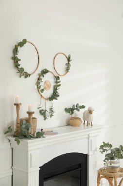 Güzel şömineli ve okaliptüs dallı şık bir oda.