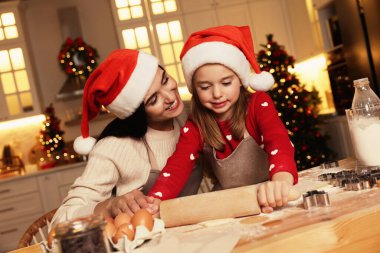 Mutlu anne ve kızı evde lezzetli Noel kurabiyeleri yapıyorlar.