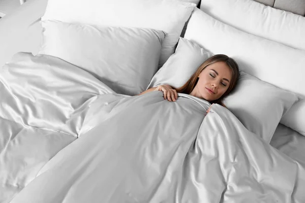 美しい女性は絹のようなリネンで快適なベッドで寝て 上記のビュー — ストック写真