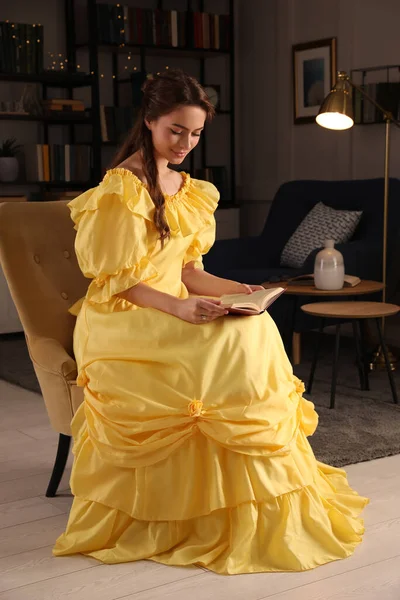 Όμορφη Νεαρή Γυναίκα Κίτρινο Βιβλίο Ανάγνωσης Φόρεμα Στο Σπίτι — Φωτογραφία Αρχείου