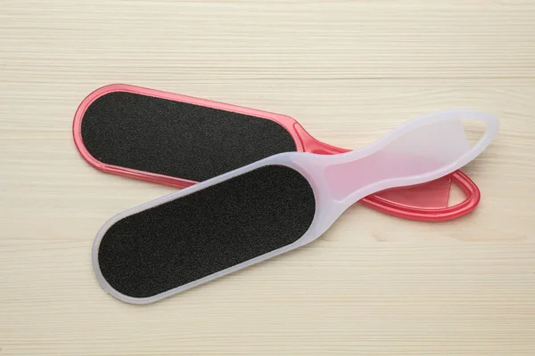 Colorful foot files on white wooden table, flat lay. Pedicure tools