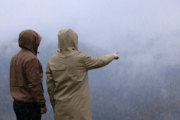 Mężczyzna Kobieta Płaszczach Przeciwdeszczowych Cieszących Się Górskim Krajobrazem Deszczu — Zdjęcie stockowe