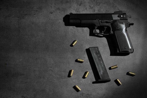Handgun, magazine and bullets on grey table, flat lay. Space for text