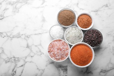 Beyaz mermer sehpanın üzerinde farklı türde tuz var, düz yerde. Metin için boşluk