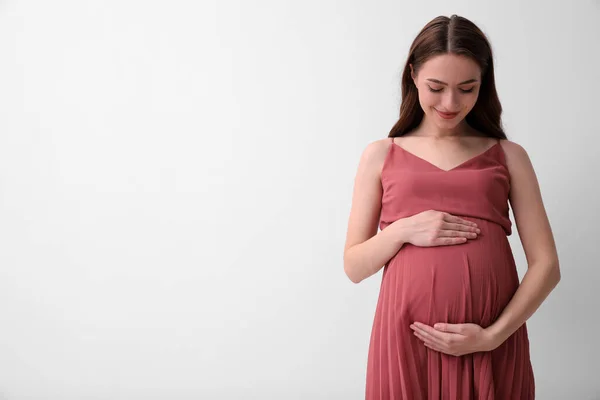 光の背景に美しい若い妊婦 テキストのスペース — ストック写真