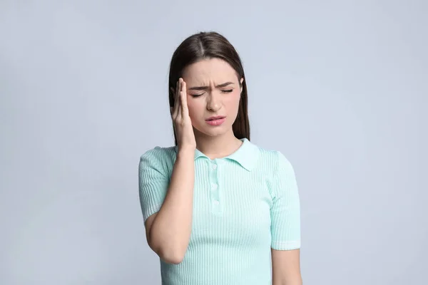 Junge Frau Leidet Kopfschmerzen Auf Leichtem Hintergrund — Stockfoto