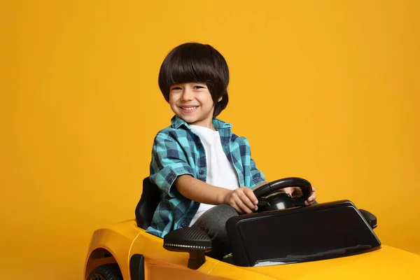 Aranyos Kisfiú Vezetés Gyerekek Elektromos Játék Autó Sárga Háttér — Stock Fotó