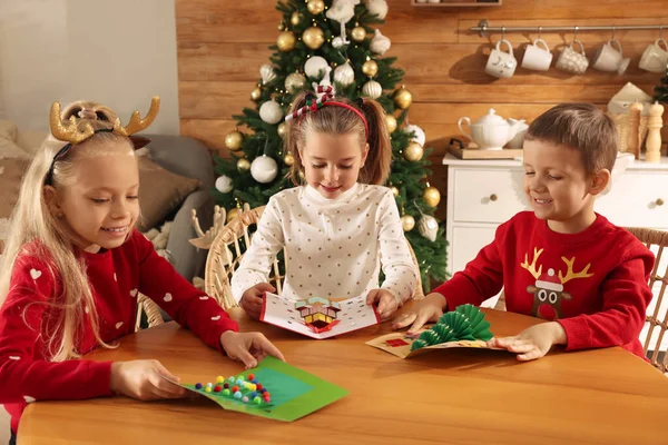 Roztomilé Malé Děti Krásnými Vánočními Pohlednicemi Stolu Zdobeném Pokoji — Stock fotografie