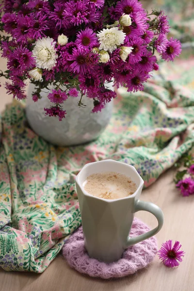 Filiżanka Aromatycznej Kawy Piękne Kwiaty Jasny Materiał Drewnianym Stole — Zdjęcie stockowe