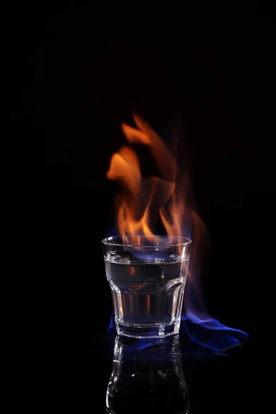 炎ウォッカでショットガラス上の黒の背景 — ストック写真