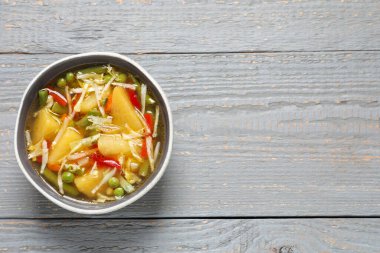 Gri ahşap masa üzerinde bir kase lezzetli şalgam çorbası, üst manzara. Metin için boşluk