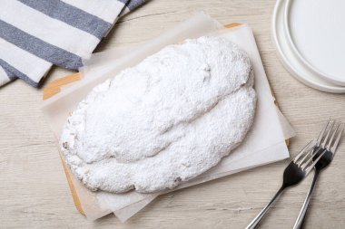 Lezzetli Stollen. Tahta masaya pudra şekeri serpiştirilmiş.