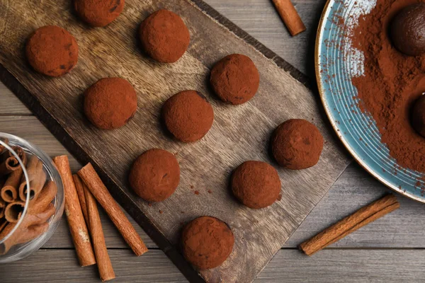 用可可粉和肉桂装饰在木制桌子上的美味巧克力松露 — 图库照片