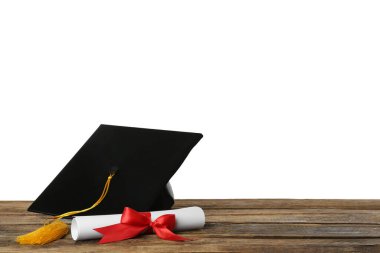 Mezuniyet şapkası ve diploması ahşap masa üzerinde beyaz arka plan, metin için boşluk