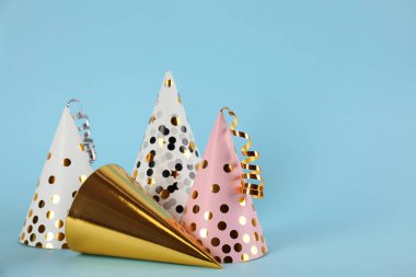 Açık mavi arka planda flamaları olan parlak parti şapkaları. Metin için boşluk