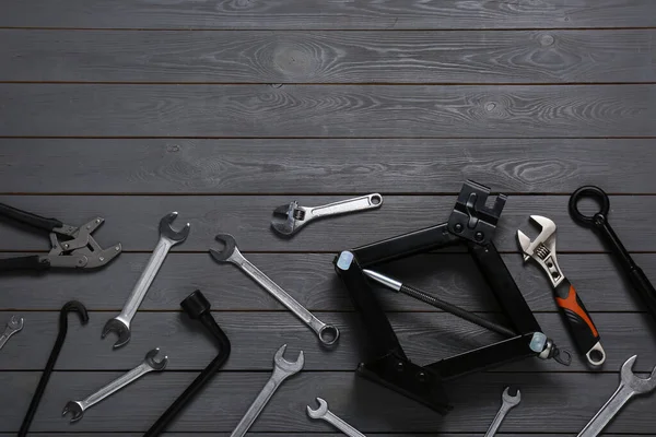 Car Scissor Jack Different Tools Grey Wooden Surface Flat Lay — Stock Photo, Image