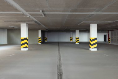 Sütunlarda uyarı çizgileri olan boş araba otoparkı