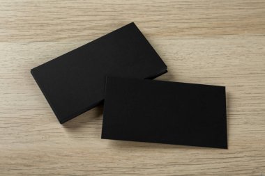 Ahşap arka planda boş siyah kartvizitler. Tasarım için model