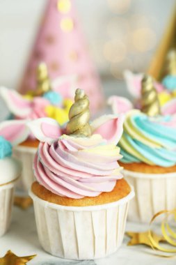 Beyaz mermer masada, bulanık ışıklara karşı şirin, tatlı tek boynuzlu at keki.