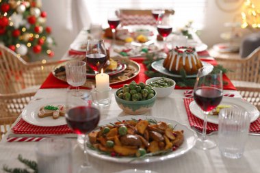 İçerideki masada lezzetli yemek ve şarapla şenlikli bir akşam yemeği. Noel arifesi